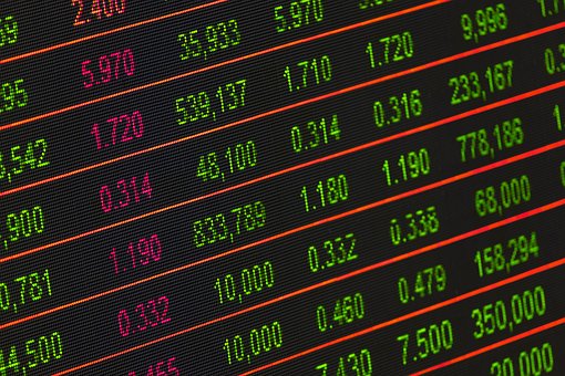 A digital display showing stock market data with numbers in red and green. Various numeric values are arranged in rows and columns, indicating financial figures such as stock prices, volume, and percentages.